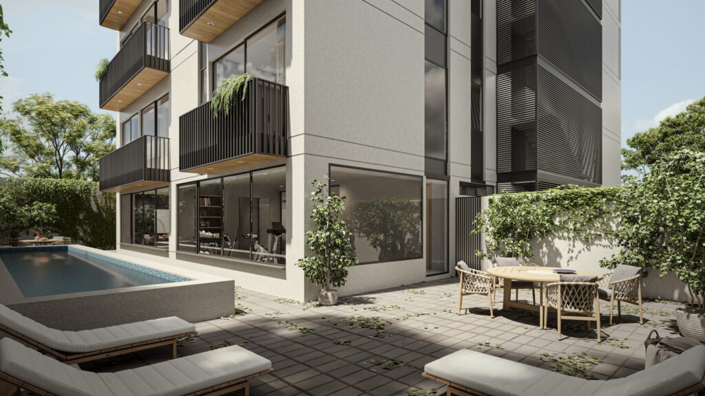 Patio exterior del edificio con alberca, sillas para tomar el sol y mesa redonda