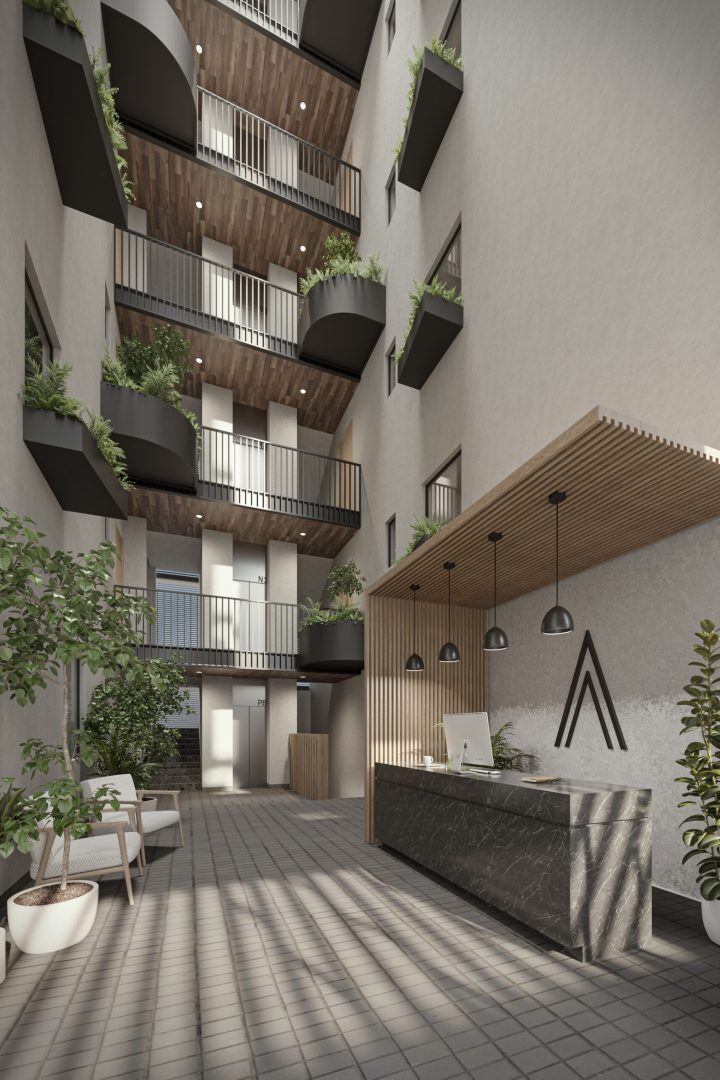 Interior de la torre con vista desde el lobie donde se puede apreciar un espacio interno vertical con vegetación y una recepción a un costado